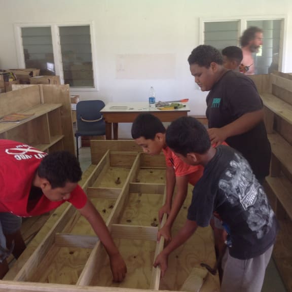 Children in Tonga put together shelves for Tonga's first public library