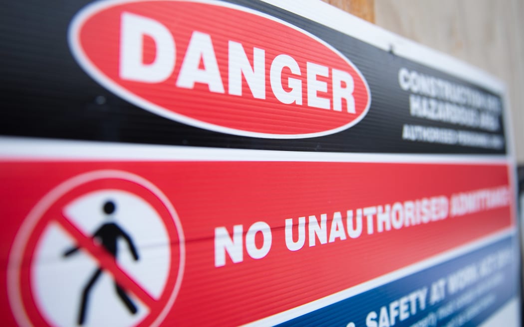 A sign warns of hazards on a building site