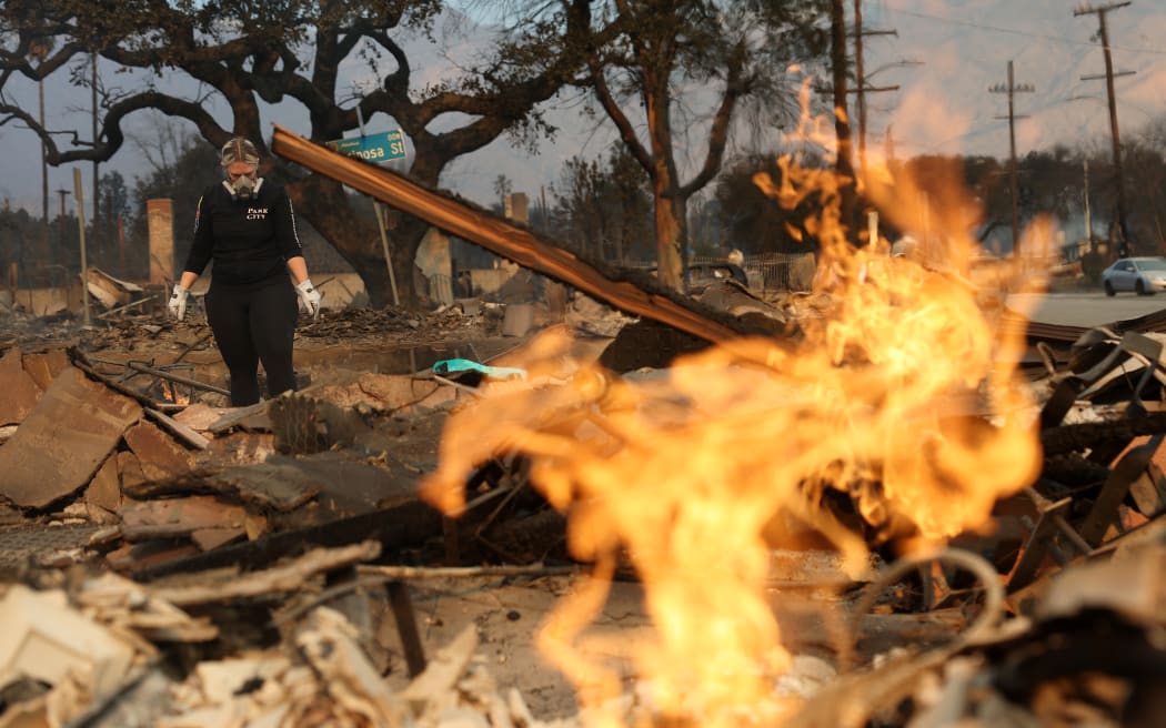 ALTADENA, CALIFORNIA - JANUARY 09: A resident inspects the remains of her home that was destroyed by the Eaton Fire on January 09, 2025 in Altadena, California. Multiple wildfires fueled by intense Santa Ana Winds are burning across Los Angeles County. At least five people have been killed, and over 25,000 acres have burned. Over 2,000 structures have also burned and almost 180,000 people are under orders to evacuate.  (Photo by Justin Sullivan/Getty Images)