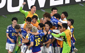 Japan's players celebrate a goal against Germany at the 2022 World Cup.