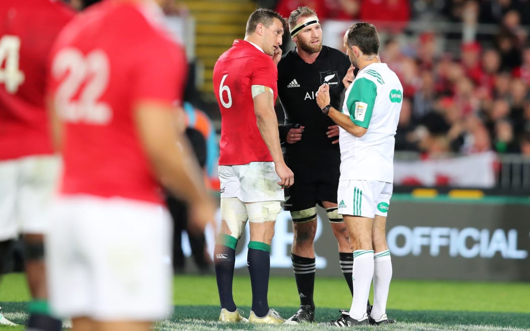 Referee Roman Porte talks to captains Sam Warburton and Kieran Read before changing his ruling from an ABs penalty to a scrum in the dying moments.