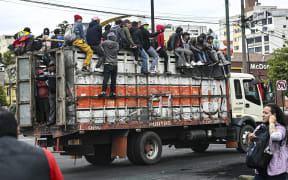 Ecuadorean indigenous ride on top of a truck heading to the House of Culture, in Quito.