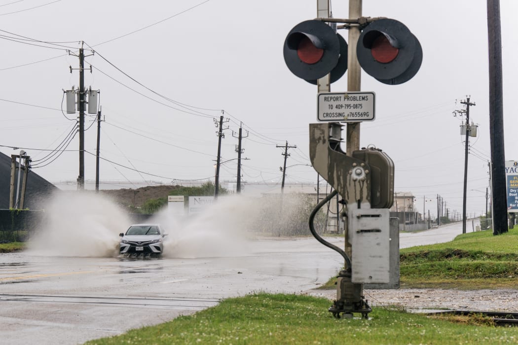 A car speeds through a flooded street ahead of the Tropical Storm Nicholas on September in Galveston, Texas.