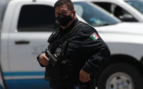 CIUDAD JUAREZ, MEXICO - JUNE 16: A police officer investigates the crime scene at the Dennys restaurant after an armed attack in Ciudad Juarez, Mexico on June 16, 2022. A group of armed men entered a branch of the Dennys restaurant to shoot five people. 4 people were killed and 1 injured in the attack. The restaurant is located in the parking lot of a shopping center located on Tecnologico Avenue. Christian Torres / Anadolu Agency (Photo by Christian Torres / ANADOLU AGENCY / Anadolu Agency via AFP)
