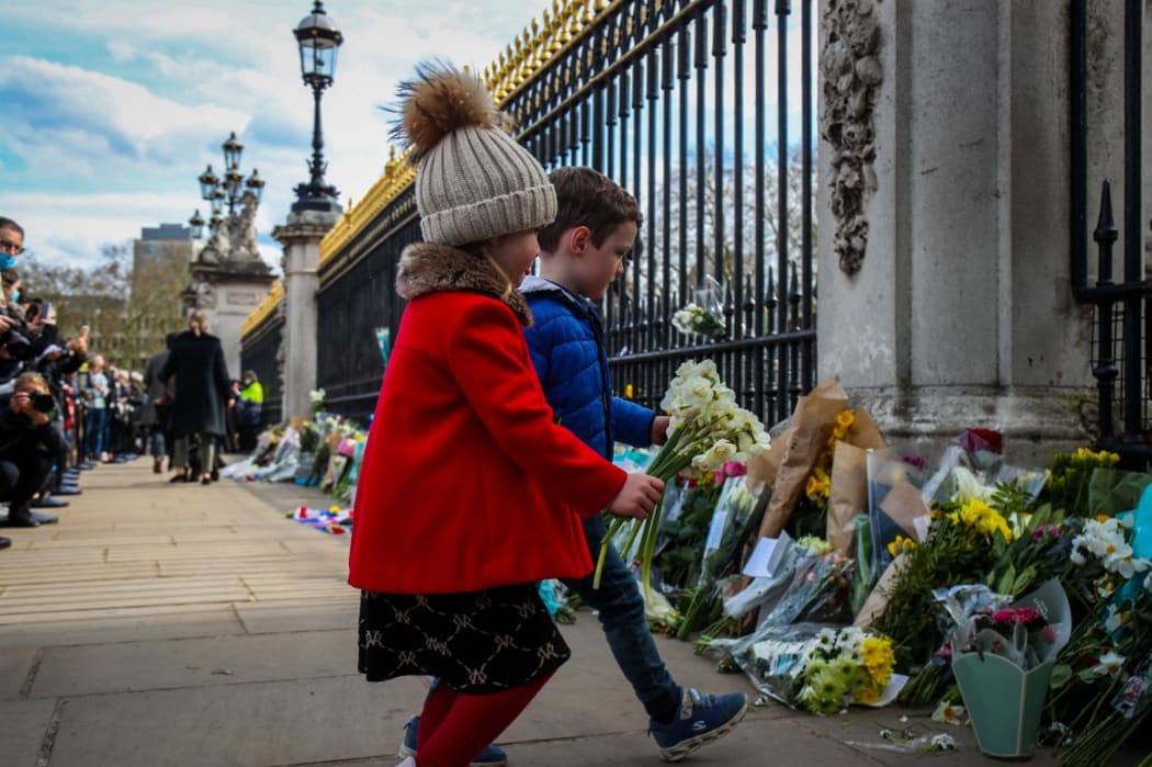 Mourners lay flowers outside Buckingham Palace following the announcement of the death of The Prince Phillip, Duke of Edinburgh at the age of 99 on Friday 9th April 2021.