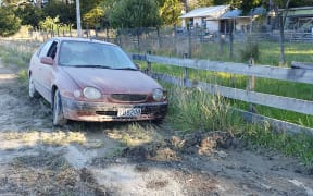 An abandoned mud covered car outside Tīnui shows how high the Whareama River got, near Wairarapa's east coast.