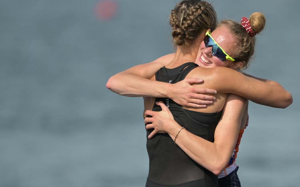 Netherlands' gold medallist Karolien Florijn (R) hugs New Zealand's silver medallist Emma Twigg after the women's single sculls final rowing competition at Vaires-sur-Marne Nautical Centre in Vaires-sur-Marne during the Paris 2024 Olympic Games on August 3, 2024. (Photo by Bertrand GUAY / AFP)