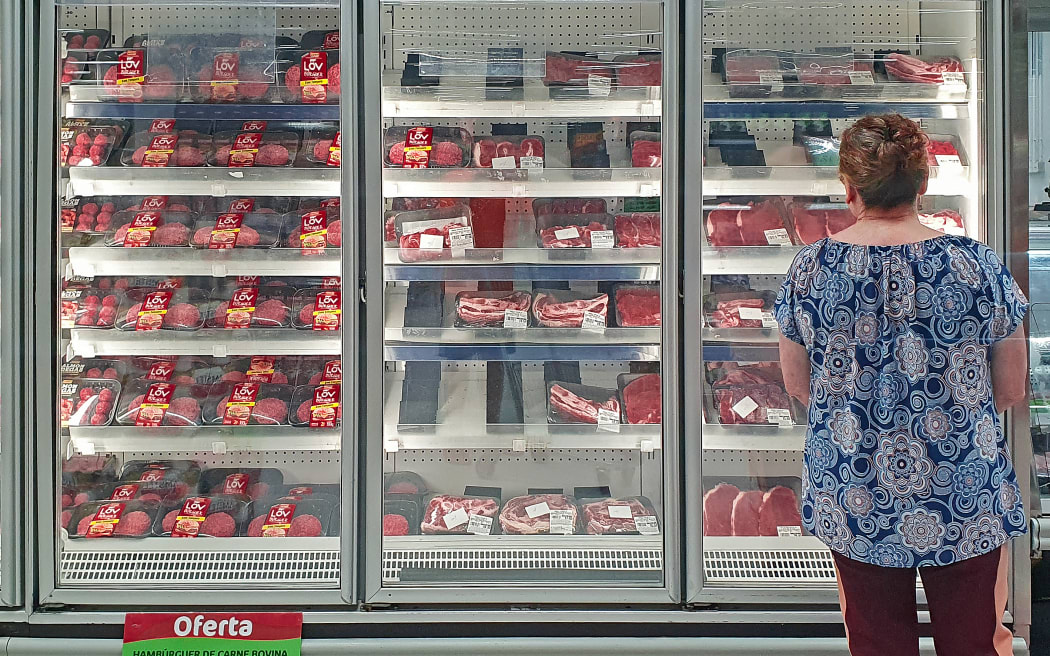 A costumer checks the beef section of a supermarket in Curitiba, Brazil, on February 23, 2023. - As of February 23, 2023, Brazil temporarily suspended its beef exports to China, its main buyer, following the official health protocol after a case of bovine spongiform encephalopathy was confirmed by the Ministry of Agriculture. Brazil made the announcement on February 22, 2023, after detecting a case of the so-called "mad cow" disease in the northen state of Para.