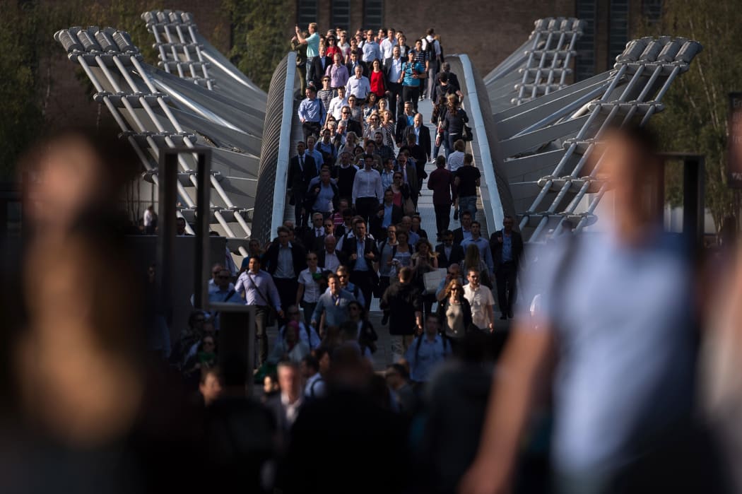 Commuters cross the river Thames using the Millennium footbridge during a tube strike in London.