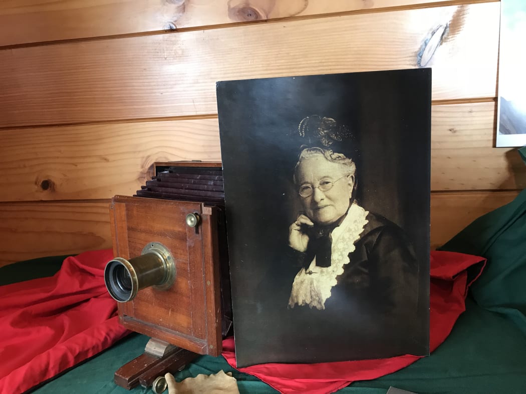 A photo of Harriet Cobb next to her original camera.