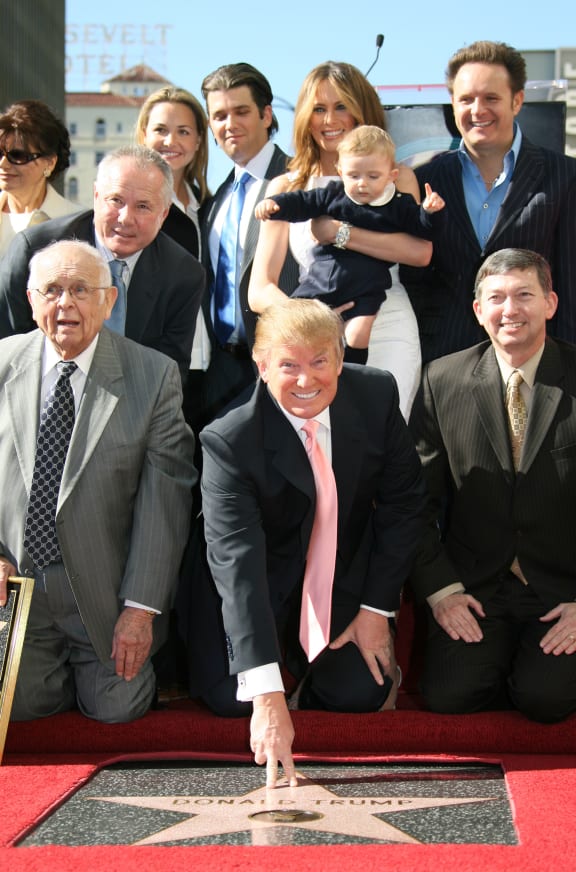This file photo taken on January 16, 2007 shows US billionaire Donald Trump (C), the producer of NBC's The Apprentice, poses after he was honored by the 2,327th star on the Hollywood Walk of Fame on Hollywood Boulevard in Hollywood, CA.