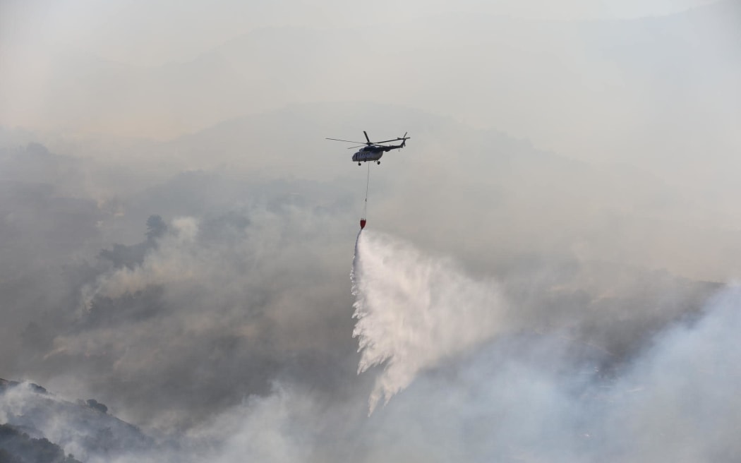 A helicopter with water in the fight to put out fires ravaging Turkey.
