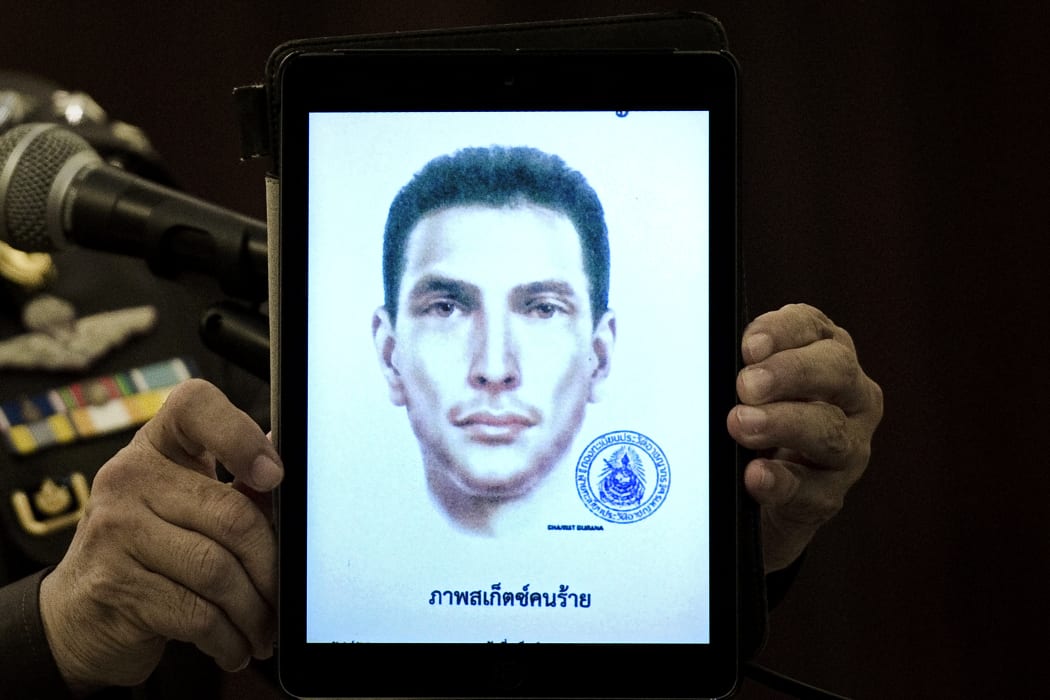 Thailand's national police spokesman Prawut Thavornsiri holds a tablet displaying a picture of an unnamed foreign man wanted by the police.