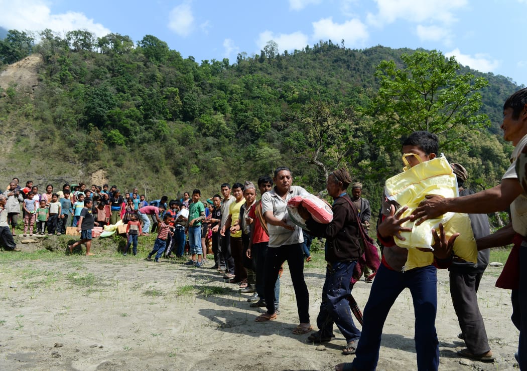 Villagers unload relief material from an Indian Army helicopter in the village of Kulgaun.