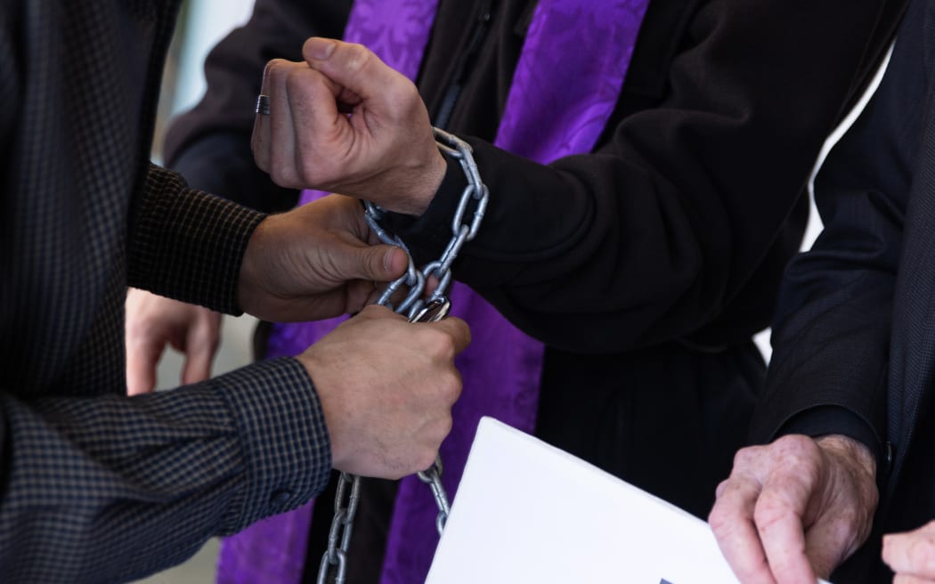 Clergy chain themselves together in protest.