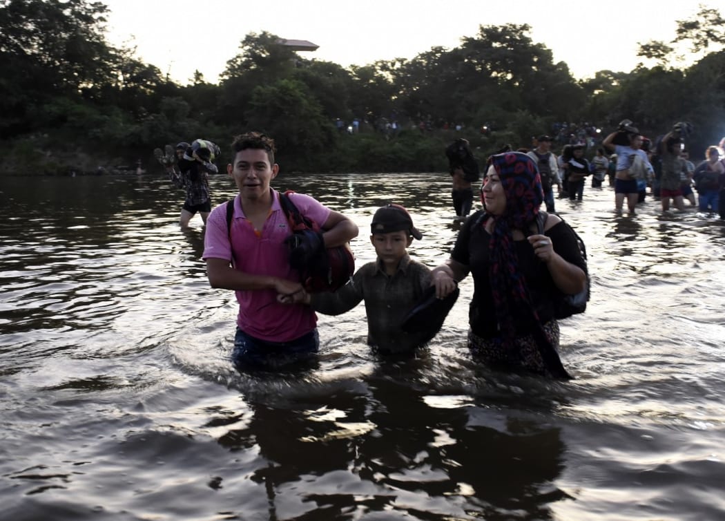 Central American migrants -mostly Hondurans heading in a caravan to the US- cross the Suchiate River from Tecun Uman, Guatemala, to Ciudad Hidalgo, Chiapas State, Mexico.