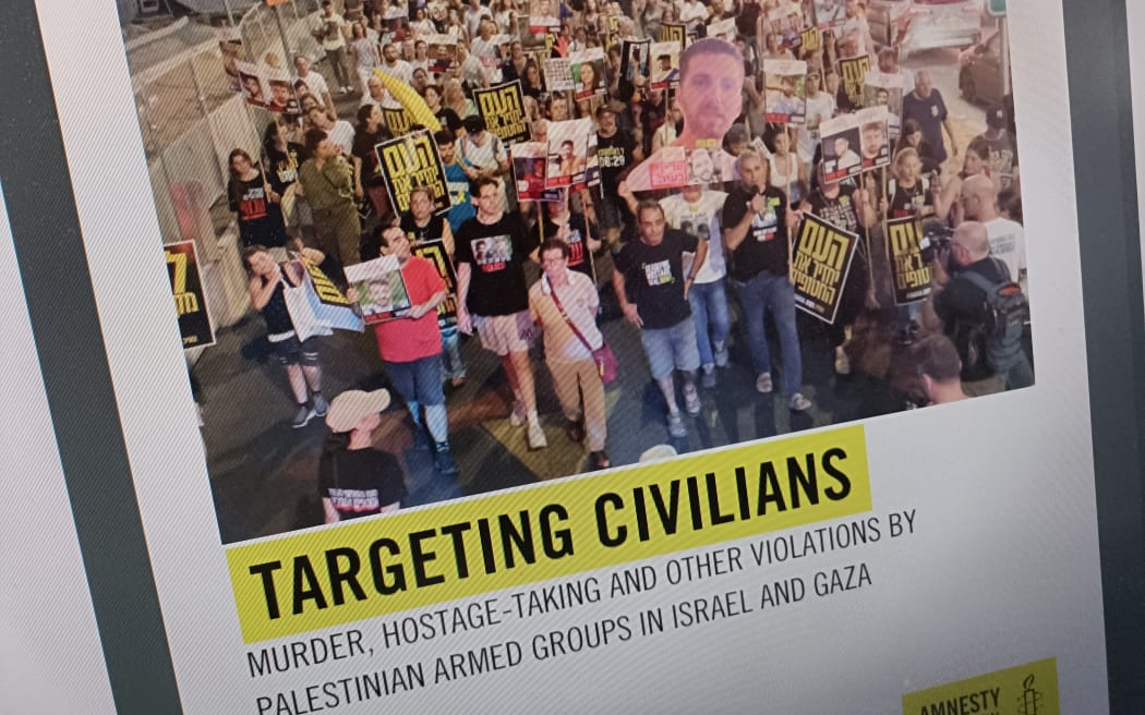 A photograph of a computer monitor showing Amnesty International's latest report on the Gaza-Israel conflict.