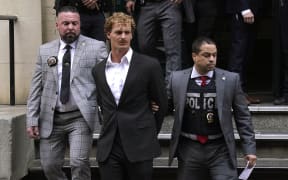 US Marine veteran Daniel Penny (C) is walked out of the New York Police Department 5th Precinct in Lower Manhattan, May 12, 2023 on his way to a arraignment after he surrendered to authorities after being charged with 2nd Degree Manslaughter in the chokehold death of Jordan Neely. The death of Jordan Neely -- widely identified as a Michael Jackson impersonator who often performed on the train -- earlier this month sparked outrage. (Photo by TIMOTHY A. CLARY / AFP)
