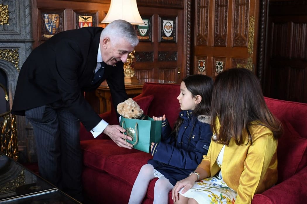 Speaker of the House of Commons Lindsay Hoyle (L) gives a present to Nazanin Zaghari-Ratcliffe and Richard Ratcliffe daughter Gabriella (C) during a meeting with them and MP Tulip Siddiq (R) at the Speaker's house, in London, on March 21, 2022.