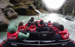 A Shotover Jet glides through the Arthurs Point Gorge