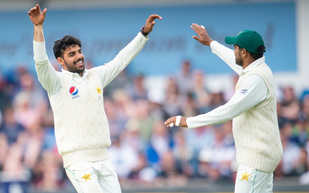 Pakistan's Shadab Khan (L) celebrates taking a wicket.