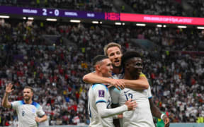 England's forward Bukayo Saka celebrates with Phil Foden (L) and Harry Kane after scoring his team's third goal during the Qatar 2022 World Cup round of 16 football match between England and Senegal at the Al-Bayt Stadium in Al Khor, north of Doha on 4 December, 2022.