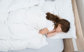 teenage girl asleep in bed