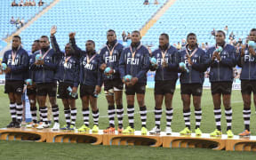 Fiji players stand on the podium after receiving the silver medal after the men's rugby sevens gold medal match against New Zealand at the Robina Stadium during the 2018 Gold Coast Commonwealth Games on the Gold Coast on April 15, 2018. / AFP PHOTO / WILLIAM WEST