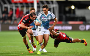 Shaun Stevenson of the Chiefs eludes Codie Taylor and Sam Whitelock of the Crusaders during the Super Rugby Pacific match, Crusaders Vs Chiefs, at Orangetheory Stadium, Christchurch, New Zealand, 12 March 2022.