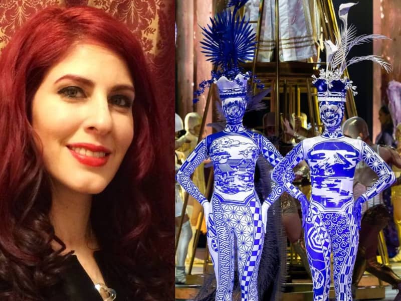 A red-haired woman smiling and two figures in graphic blue and white catsuits.