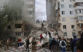 Firefighters and volunteers operate to secure the area on the site of a partially collapsed apartment building in Belgorod, 12 May, 2024.