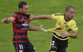 Manny Muscat (R) of the Phoenix tussles with West Sydney's Brendon Santalab.