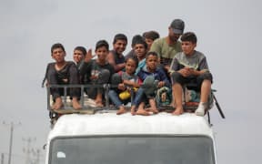 Palestinians fleeing Rafah with their belongings following renewed Israeli strikes in the city in the southern Gaza Strip arrive in Khan Yunis on May 28, 2024, amid the ongoing conflict between Israel and the Palestinian Hamas militant group. (Photo by Bashar TALEB / AFP)