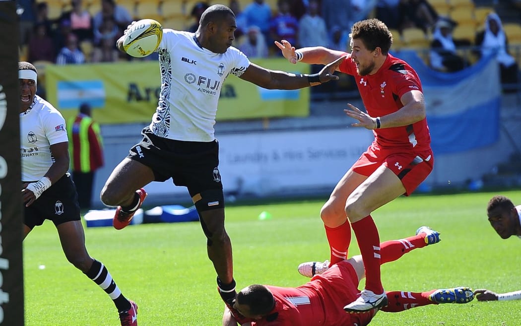 Fiji's Vatemo Ravouvou fends off tackles to score a try against Wales on Day 1 of the IRB Sevens Series Rugby Tournament in Wellington, 2015.