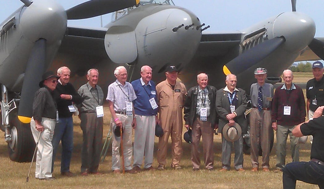 WWII veterans in front of a Mosquito fighter bomber.