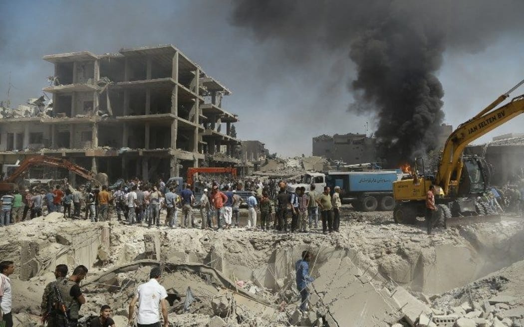 Residents gather at the site of a bomb attack in Syria's northeastern city of Qamishli.