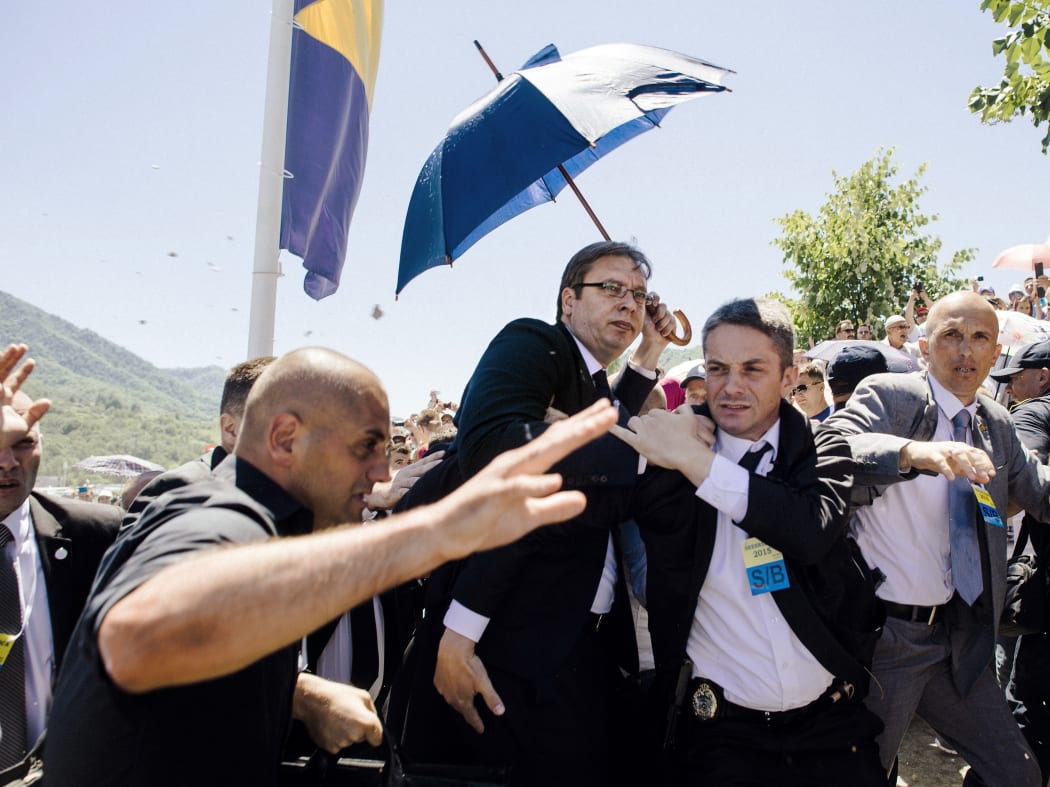 Bodyguards try to protect Serbian Prime Minister Aleksandar Vucic (centre) from stones hurled at him by an angry crowd.