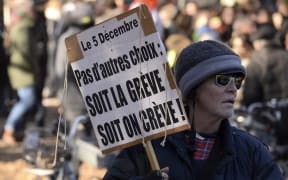 A man holds a placard reading "No choice: the strike or the death" during a demonstration against the pension overhauls, in Bordeaux, on December 5, 2019, as part of a national general strike.