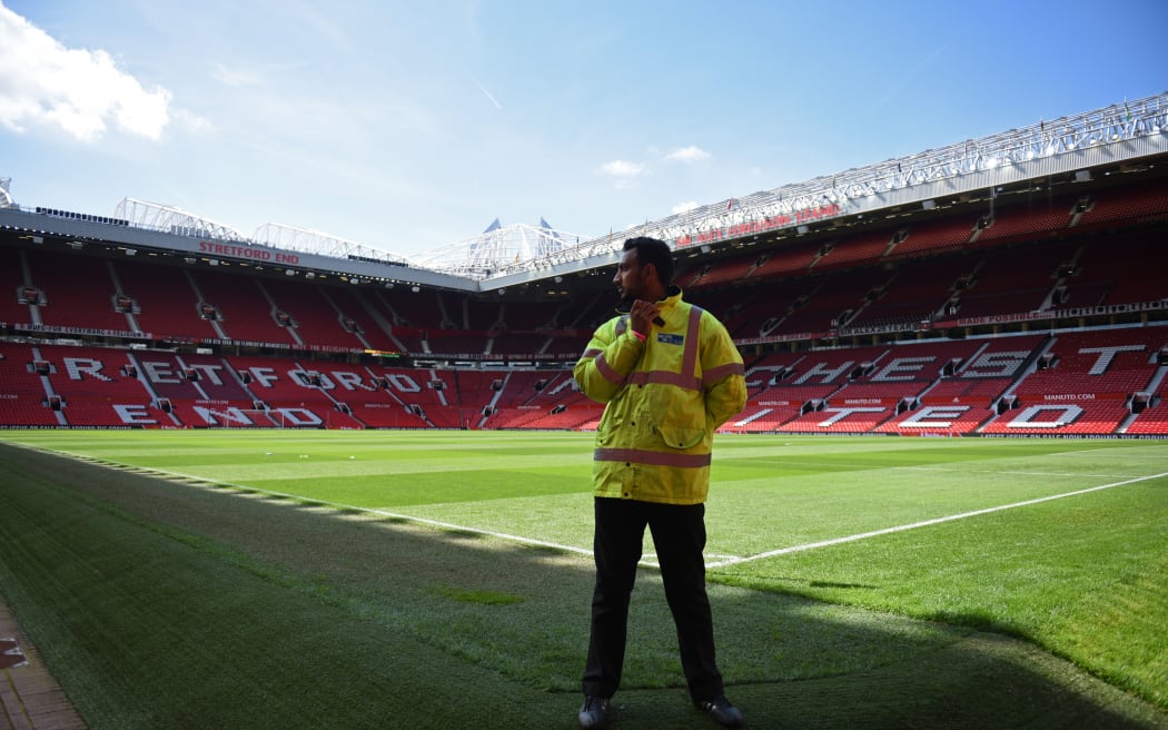 A security guard stands at the empty stadium after a EPL match was called off due to a bomb scare.