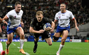 Damian McKenzie dives to score a try in the All Blacks' Rugby World Cup match against Namibia.