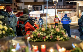Police control access to the street where a fire ripped through a crowded bar during New Year's Eve celebrations in the Alpine ski resort town of Crans-Montana on January 1, 2026. Several dozen people are presumed dead and around 100 injured after a fire ripped through a crowded bar in the luxury Swiss ski resort of Crans-Montana, Swiss police said on January 1, 2026. Police, firefighters and rescuers rushed to the popular resort, which is set to host the Ski World Cup from January 30, after the fire broke out in the early hours of New Year's Day. (Photo by MAXIME SCHMID / AFP)