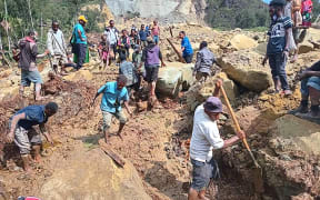 This handout photo taken and received on May 26, 2024 from the International Organization for Migration shows people digging at the site of a landslide at Yambali Village in the region of Maip Mulitaka, in Papua New Guinea's Enga Province. More than 670 people are believed dead after a massive landslide in Papua New Guinea, a UN official told AFP on May 26 as aid workers and villagers braved perilous conditions in their desperate search for survivors. (Photo by Mohamud Omer / International Organization for Migration / AFP) / RESTRICTED TO EDITORIAL USE - MANDATORY CREDIT "AFP PHOTO / INTERNATIONAL ORGANIZATION FOR MIGRATION / MOHAMUD OMER - NO MARKETING NO ADVERTISING CAMPAIGNS - DISTRIBUTED AS A SERVICE TO CLIENTS - NO ARCHIVE