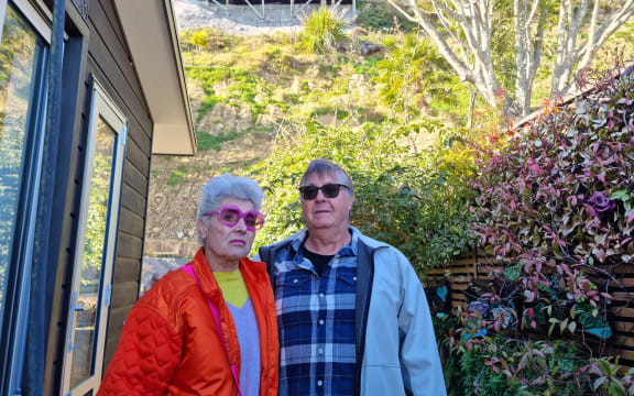 Julie Ambrose and Geoff Moffett with the exposed slope behind their home.