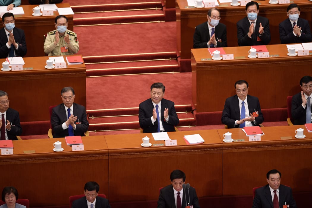 China's President Xi Jinping (centre) applauds after the vote on a proposal to draft a Hong Kong security law during the closing session of the National People's Congress at the Great Hall of the People in Beijing.