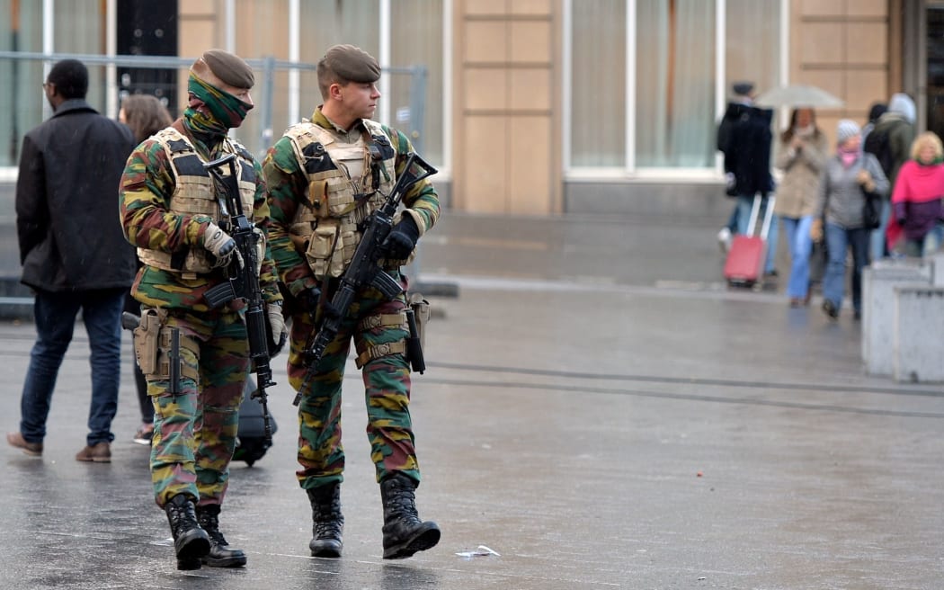 Soldiers patrol streets in Brussels as the alert status is raised to the highest level.