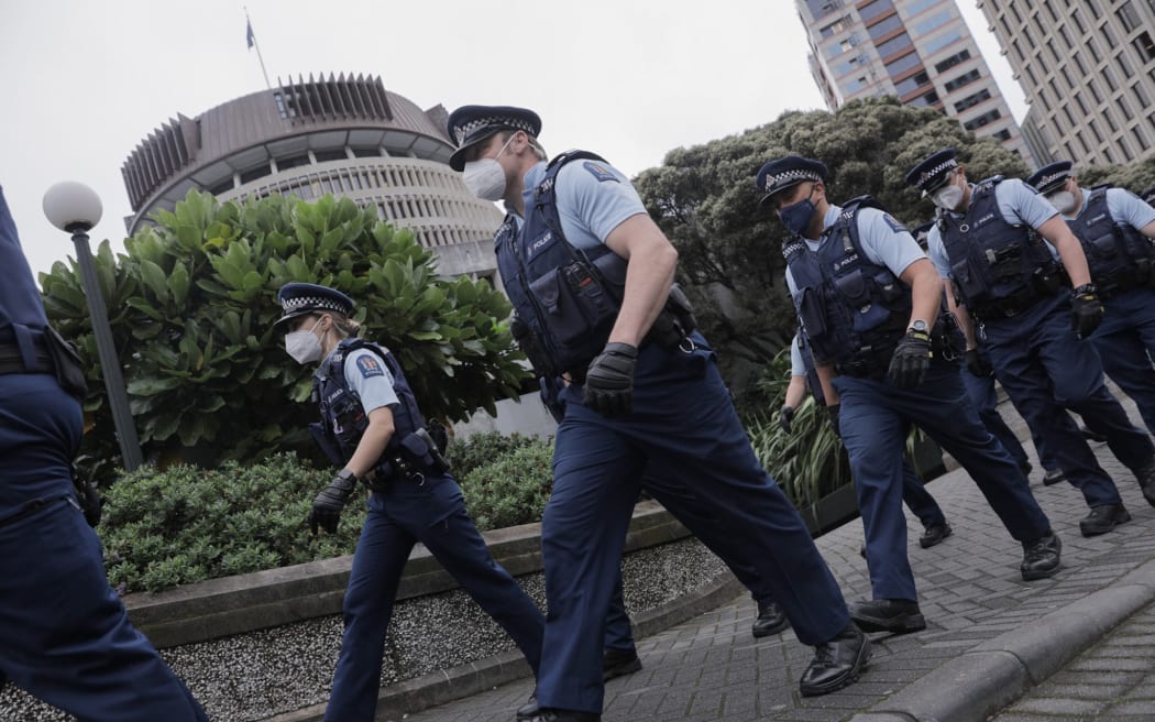 Line of police arriving at the back of Parliament ahead of an anti-newsprotest.