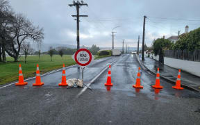 A police cordon blocking off Eglinton Road in Dunedin where a man died.