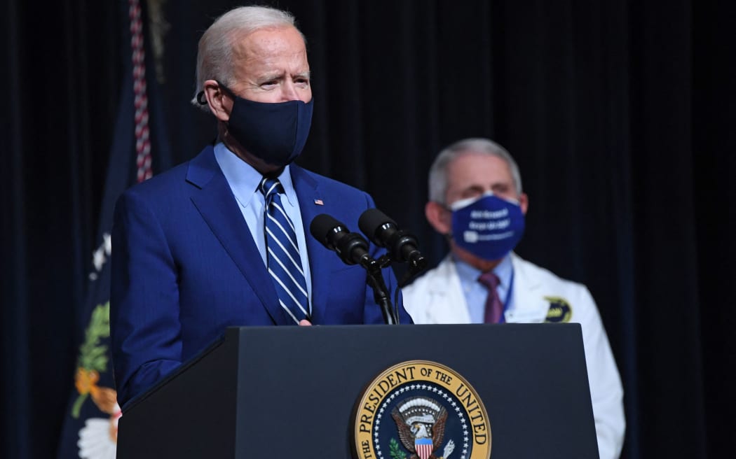 US President Joe Biden speaks, flanked by White House Chief Medical Adviser on Covid-19 Dr Anthony Fauci (R) during a visit to the National Institutes of Health (NIH) in Bethesda, Maryland, February 11, 2021.