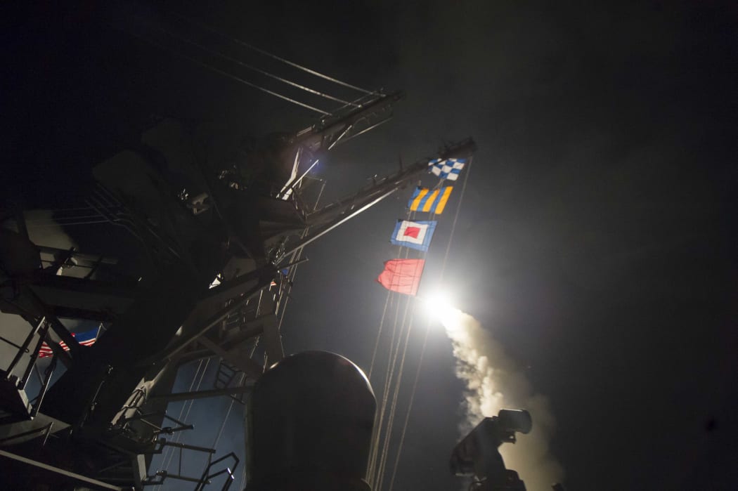 In this image released by the US Navy, the USS Ross fires a Tomahawk missile at a Syrian air force airfield (7 April 2017).