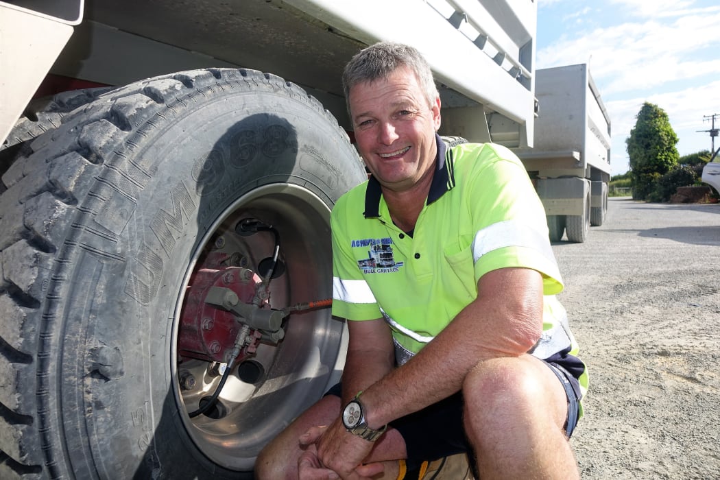 Truck driver by big vehicle wheel.